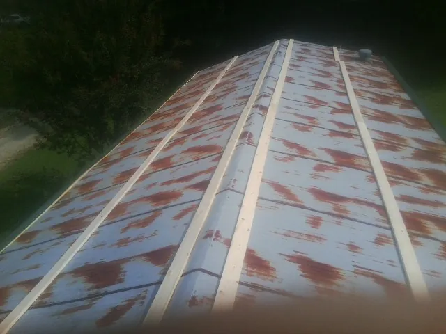 Rusted metal roof panels with new wood purlins before replacement — Storm Damage Roof Repair in Tewksbury by Roofing Brothers