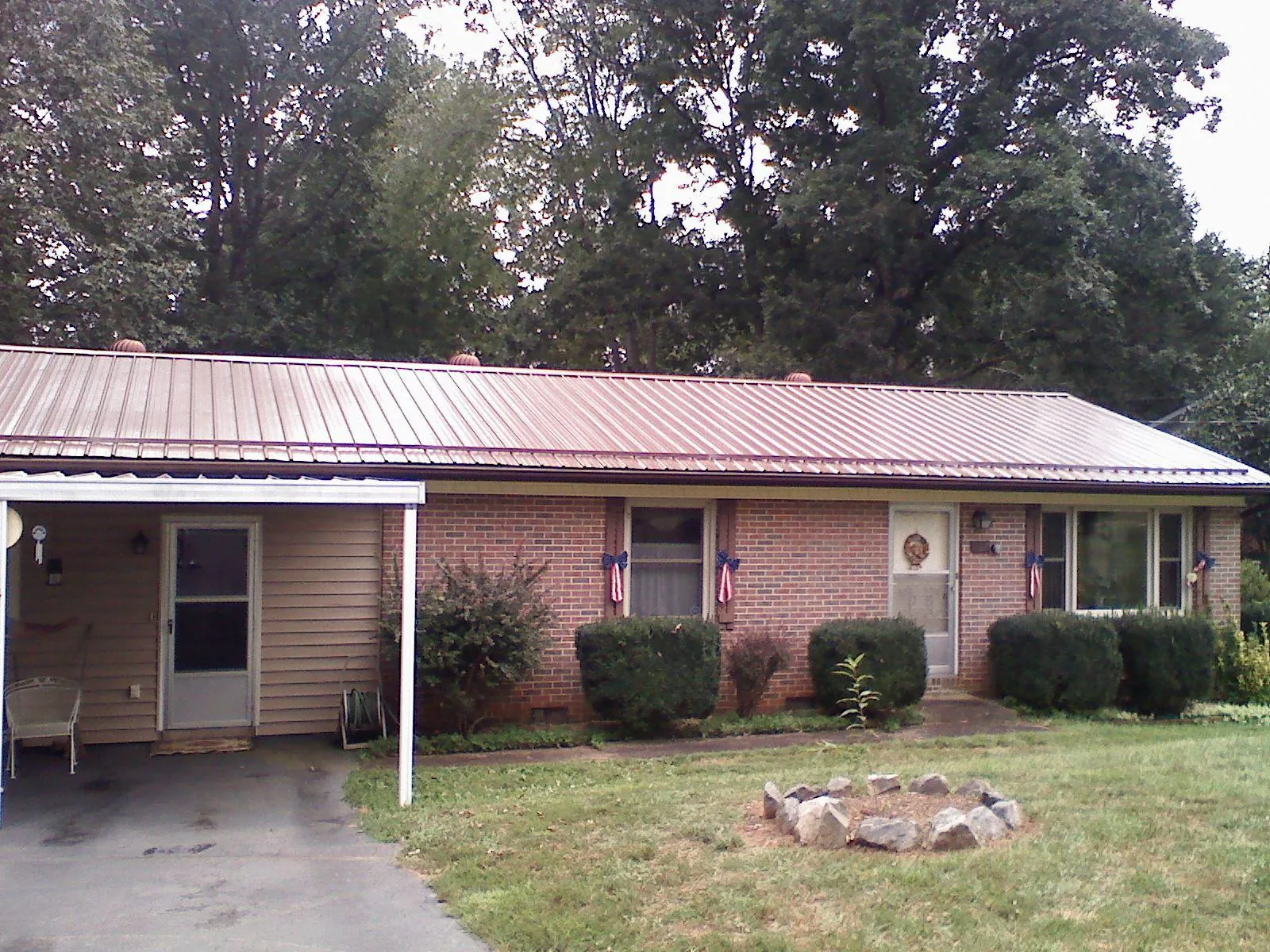 Bronze metal roof and carport on a brick ranch home — Roof Repair work by our crew in Tewksbury